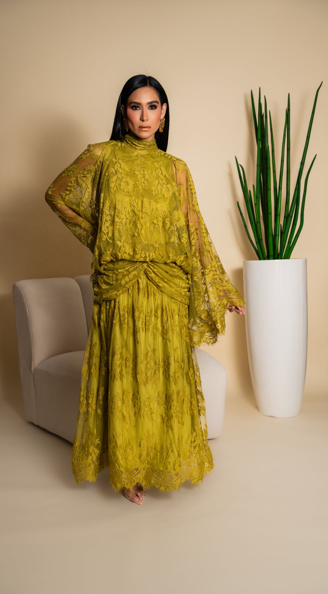 Elegant olive green lace dress with dramatic sleeves and intricate floral detailing