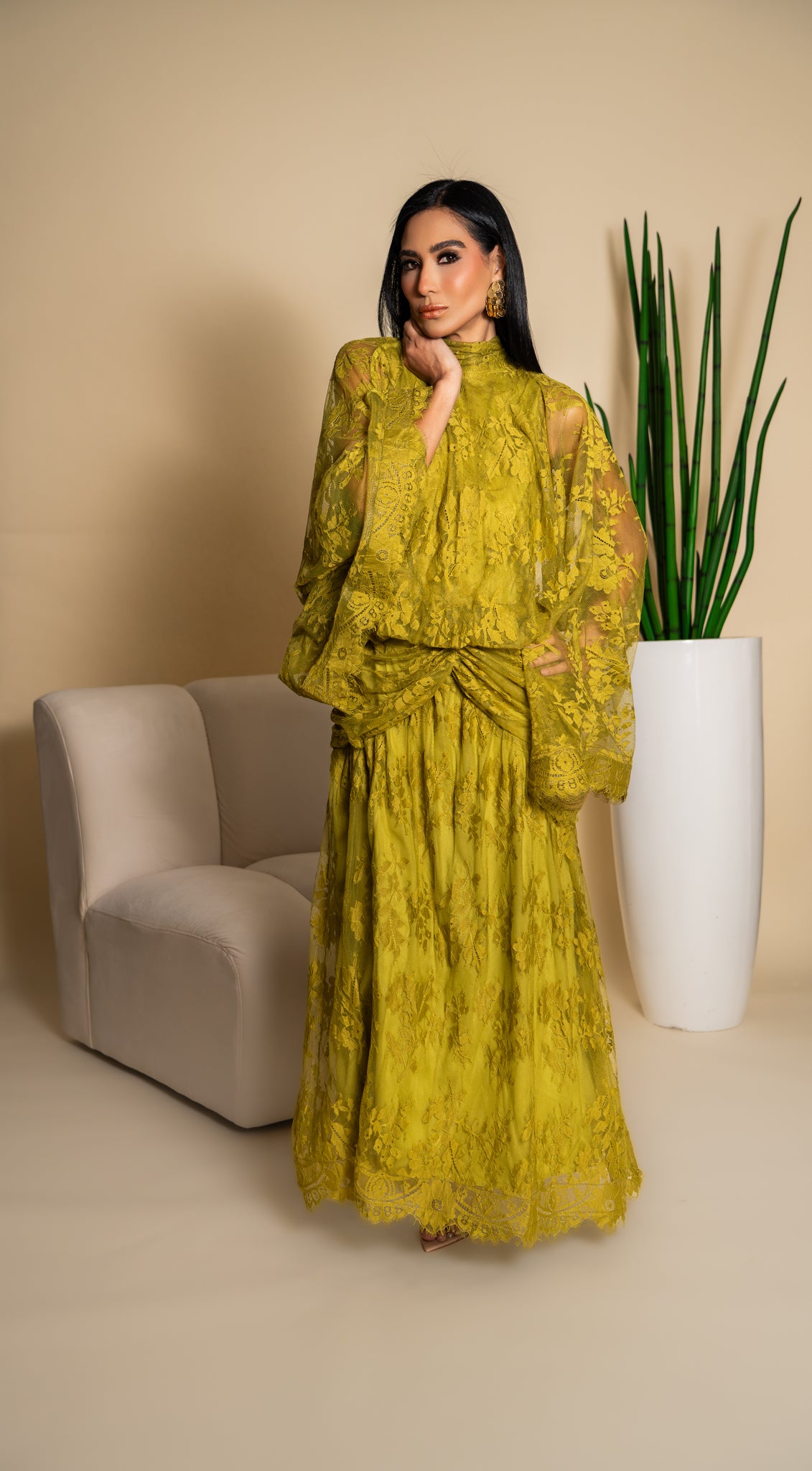 Elegant olive green lace dress with dramatic sleeves and intricate floral detailing